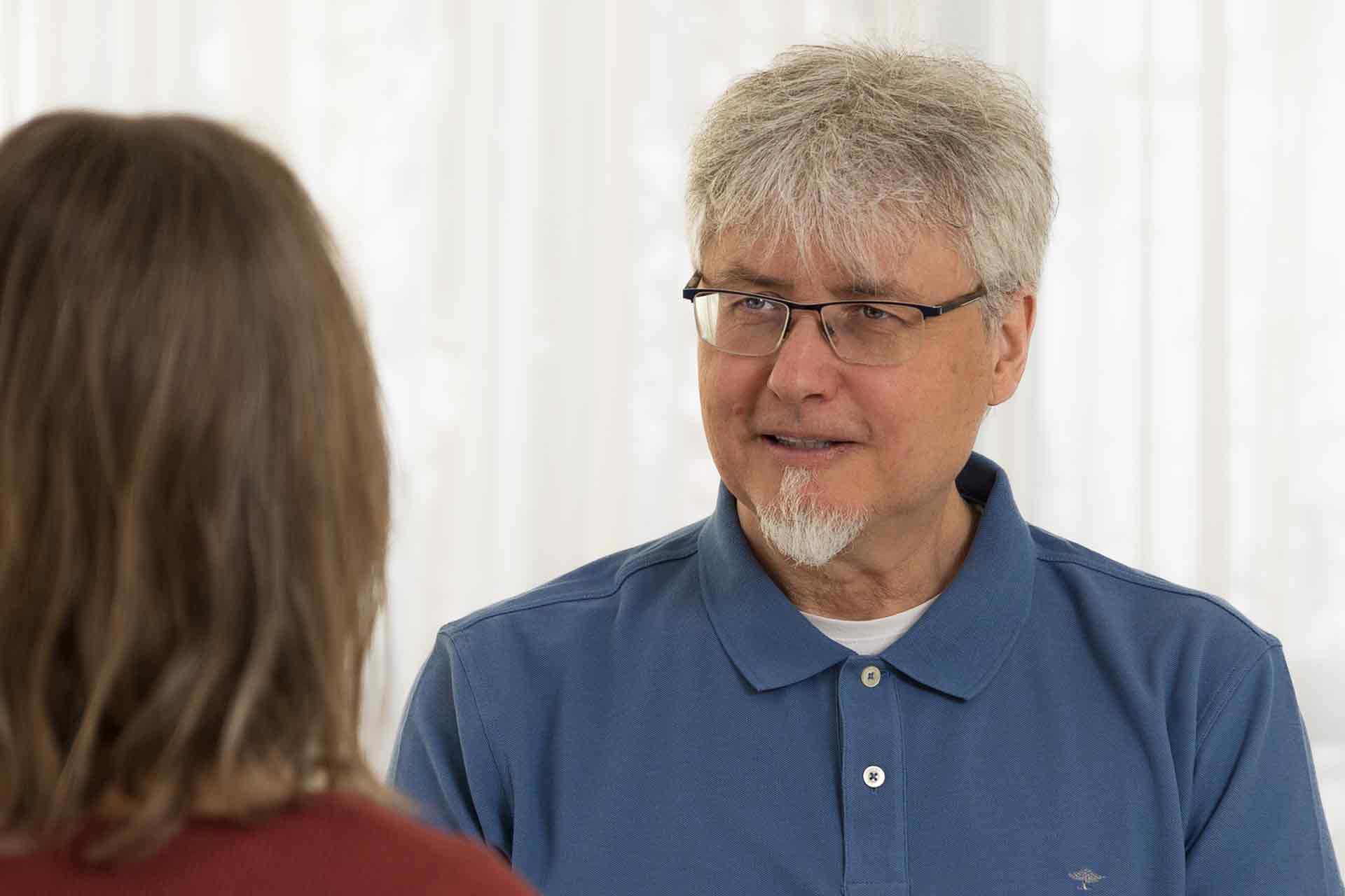 Daniel Pfister sitzt einer Klientin gegenüber